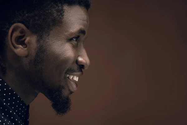 Vue latérale de souriant homme afro-américain isolé sur brun — Photo de stock