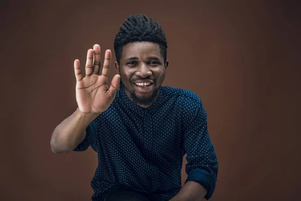 Smiling african american man giving high five isolated on brown — Stock Photo
