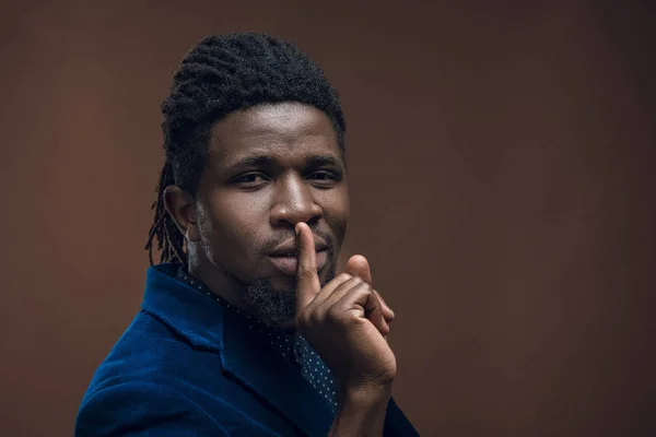Афроамериканський чоловік показує жест мовчання ізольований на коричневому — стокове фото