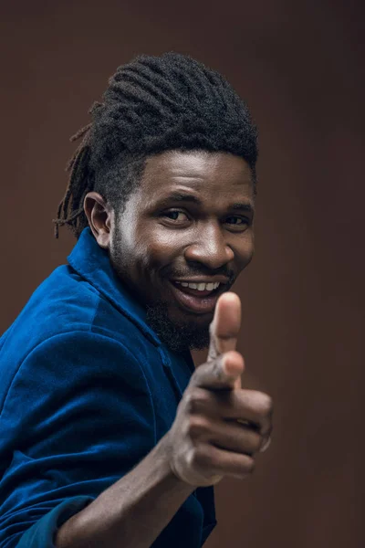 Lächelnder afrikanisch-amerikanischer Mann zeigt isoliert auf braune Kamera — Stockfoto
