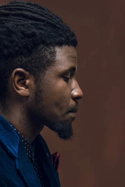 Side view of handsome african american man with dreadlocks isolated on brown — Stock Photo