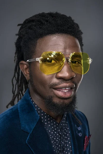 Portrait of handsome african american man in yellow sunglasses isolated on gray — Stock Photo