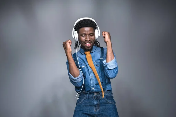 Glücklich afrikanisch-amerikanischer Mann hört Musik auf grau — Stockfoto