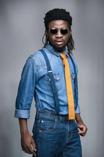 Hombre afroamericano con estilo en gafas de sol negras aisladas en gris - foto de stock