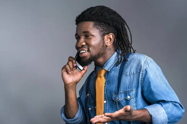 Felice uomo africano americano che parla da smartphone isolato su grigio — Foto stock