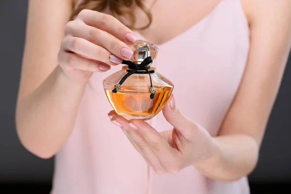 Tiro recortado de la mujer botella de apertura de perfume - foto de stock