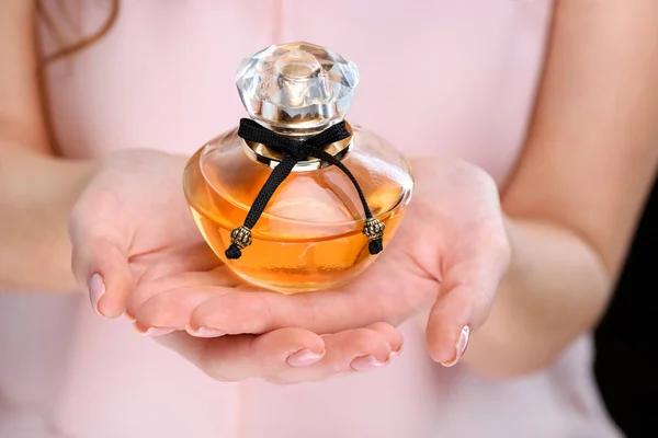 Cropped shot of woman holding bottle of perfume — Stock Photo