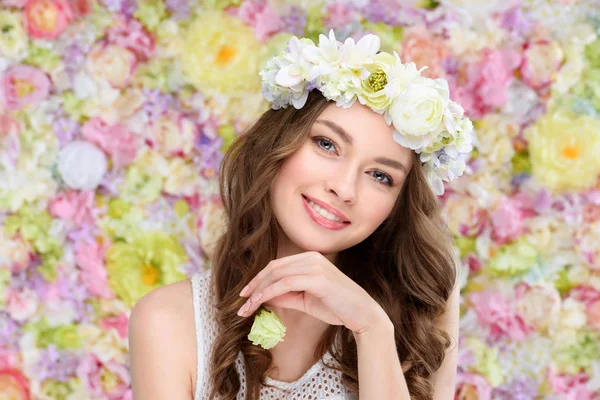 Sonriente joven en corona floral con brote de rosa floreciente - foto de stock