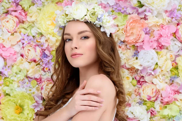 Sinnliche junge Frau in floralem Kranz auf floralem Hintergrund — Stockfoto