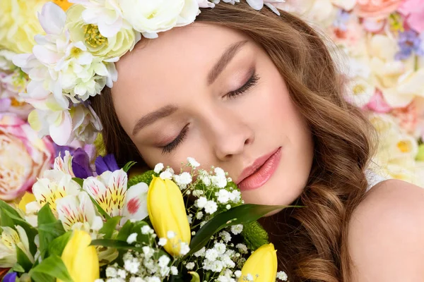 Nahaufnahme Porträt einer sinnlichen jungen Frau mit Blumenkranz und Blumenstrauß — Stockfoto