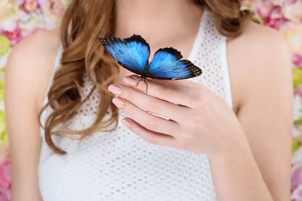 Cropped shot of woman with beautiful blue butterfly on hand — Stock Photo