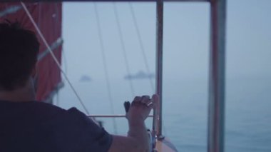 Kaptan güvertede büyük geminin bir direksiyon. Denizci bir yelkenli dümen. Yelkenli tekne yat. Tayland Islands yakınındaki açık okyanus, kaba su üzerinde yelken gemi.