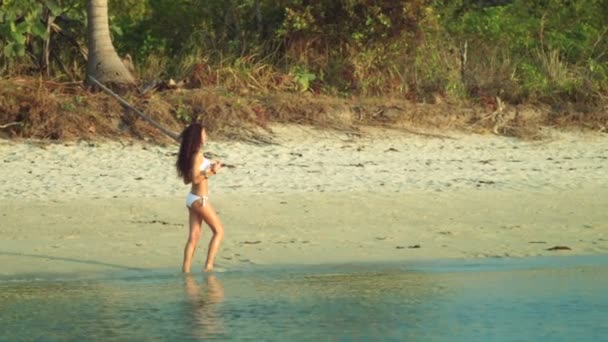 Mädchen, das barfuß auf dem Wasser entlang eines einsamen Strandes läuft. Frau, die an einem tropischen Strand geht. junges Mädchen an einem leeren tropischen Strand auf der einsamen, leeren Insel. Meerblick, Zeitlupe — Stockvideo