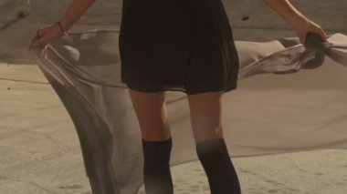 Güzel kız positing, dans, koşma, La nehrine yürüme sallayarak kumaş ile. Sanayi Bölgesi moda videoshoot.