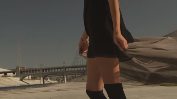 Piękna dziewczyna z tkaniny macha positing, taniec, bieganie, chodzenie na rzece La. Przemysłowej dzielnicy mody akcja na planie teledysku. — Wideo stockowe