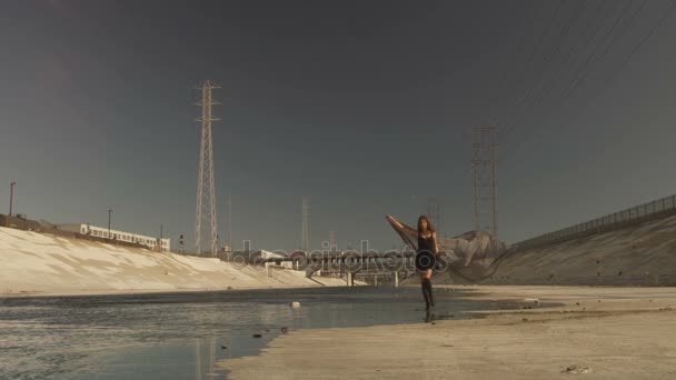 Krásná dívka s vlající látky positing, tanec, běh, chůze v řece La. Průmyslové oblasti módní videoshoot. — Stock video