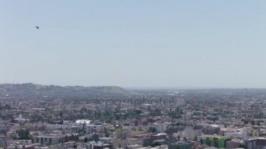 Los Angeles, Beverly Hills alan uçan helikopter. İniş için ışık helikopter yaklaşım. Çapraz olarak arka planda şehir binaları ile azalan helikopter. Antenler Ms bir polis helikopteri uçan.