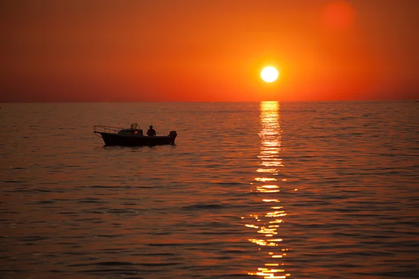 Fisherman in a boat during sunset — Stock Photo, Image