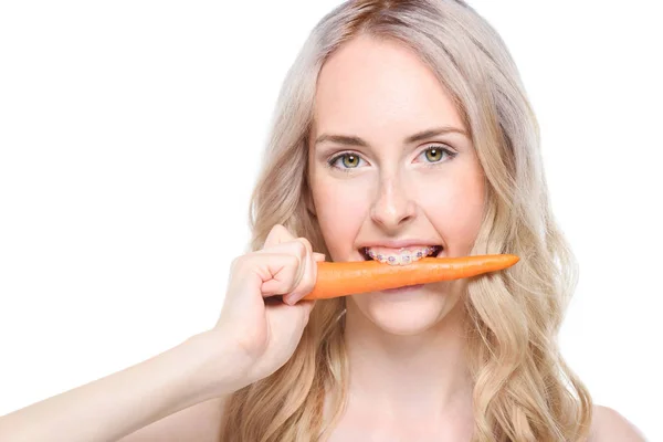 Mulher tomando mordida de cenoura — Fotografia de Stock