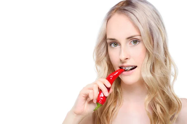 Woman taking bite of chili pepper — Free Stock Photo