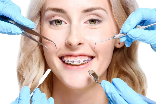 Mani che tengono gli strumenti dentisti vicino alla donna — Foto Stock