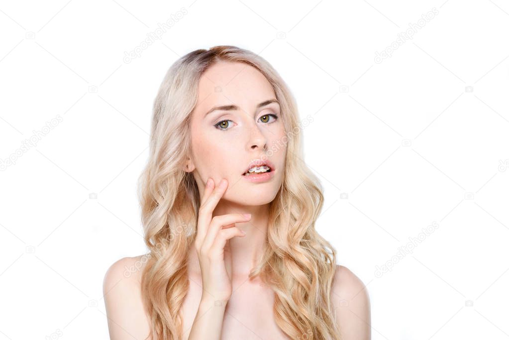 Woman with braces touching face