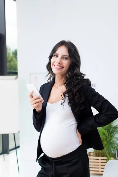 Pregnant businesswoman using smartphone — Stock Photo, Image