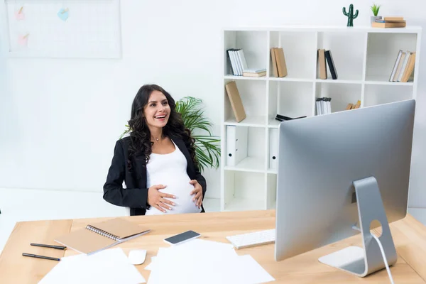 Pregnant businesswoman touching her tummy — Stock Photo, Image