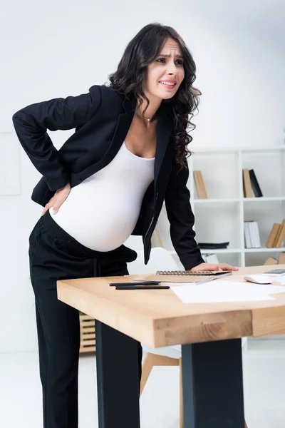 Empresária grávida com dor nas costas — Fotografia de Stock