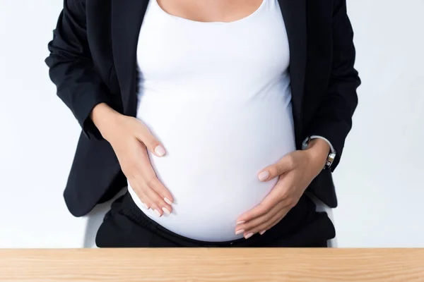 Zwangere zakenvrouw haar buik aan te raken — Gratis stockfoto