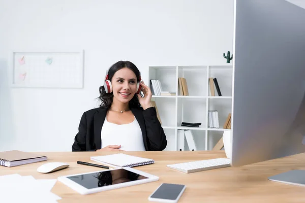 Pregnant businesswoman relaxing and listening music — Stock Photo, Image