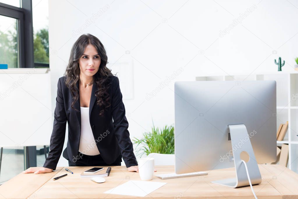pregnant businesswoman looking at computer