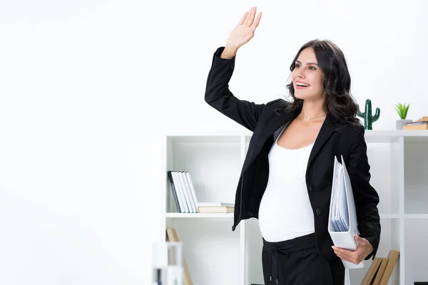 Pregnant businesswoman waving hand — Stock Photo, Image