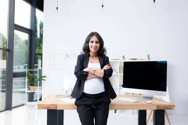 pregnant businesswoman with crossed arms