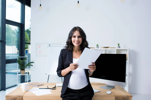 Pregnant businesswoman with paperwork — Stock Photo, Image