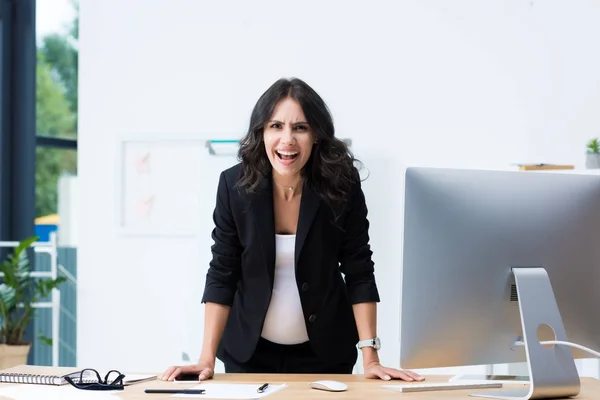 Pregnant businesswoman screaming at camera — Stock Photo, Image