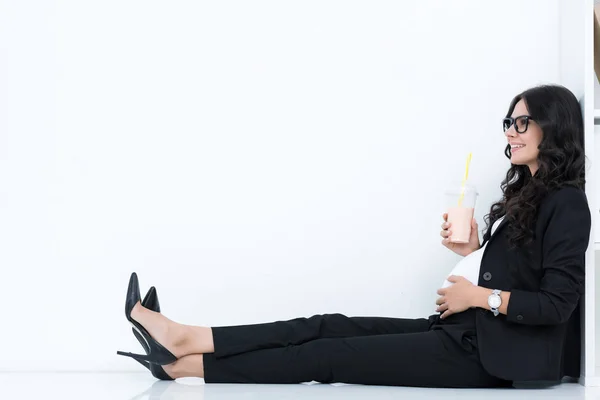 Pregnant businesswoman drinking milkshake — Stock Photo, Image