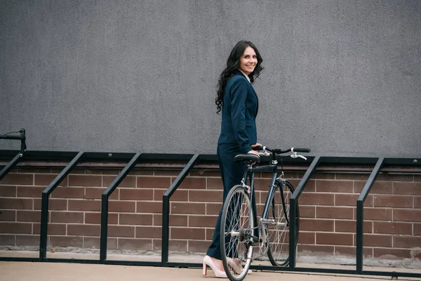 Empresária estacionamento bicicleta — Fotografia de Stock