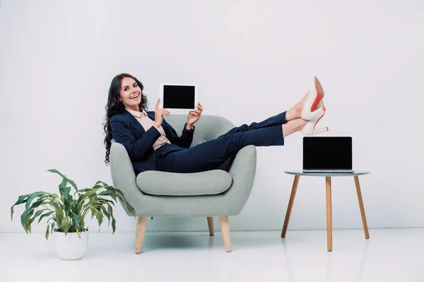 Business woman with tablet sitting in armchair — стоковое фото