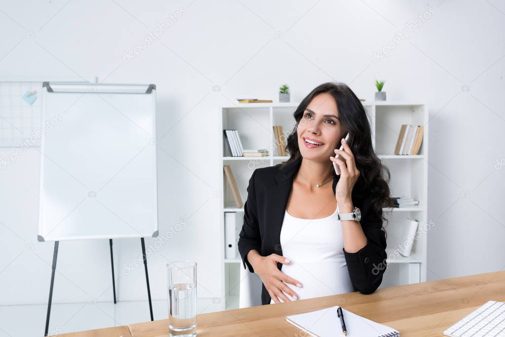 pregnant businesswoman talking by phone