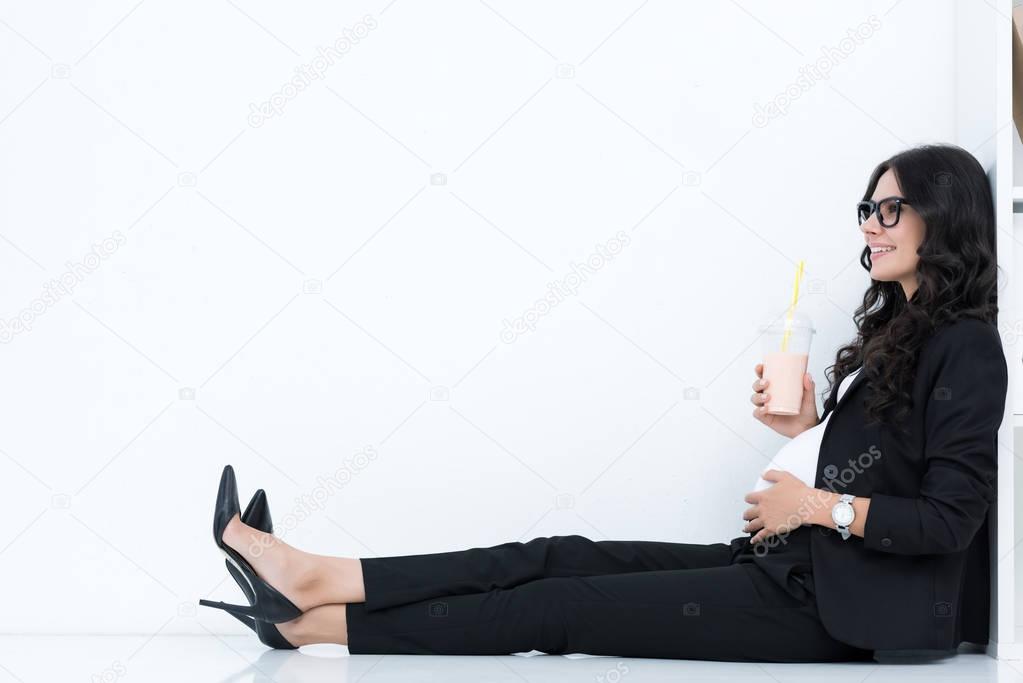 pregnant businesswoman drinking milkshake