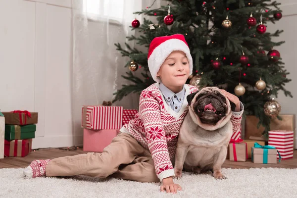 Junge streichelt seinen Hund an Weihnachten — Stockfoto