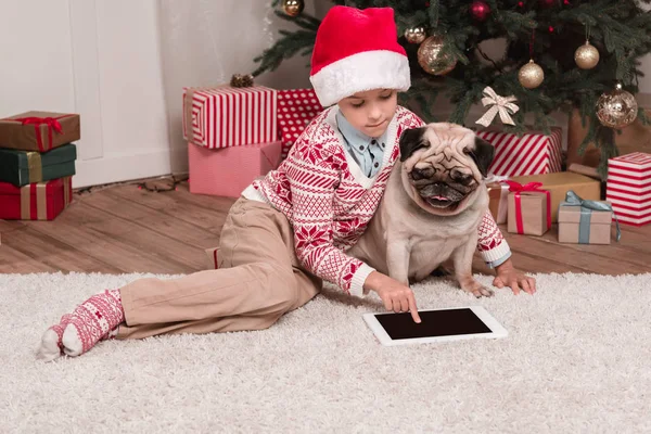 Boy with pug using tablet on christmas — Stock Photo, Image