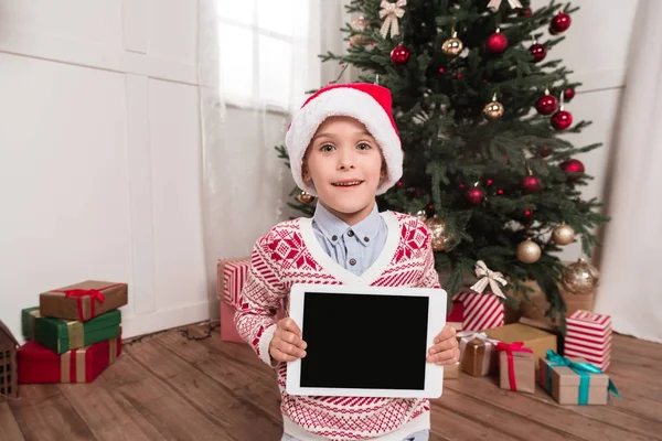 Noel Baba şapkalı tablet tutan çocuk