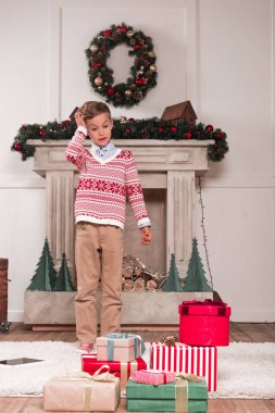 boy looking at heap of gifts clipart