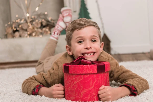 Boy laying on floor with gift — Stock Photo, Image