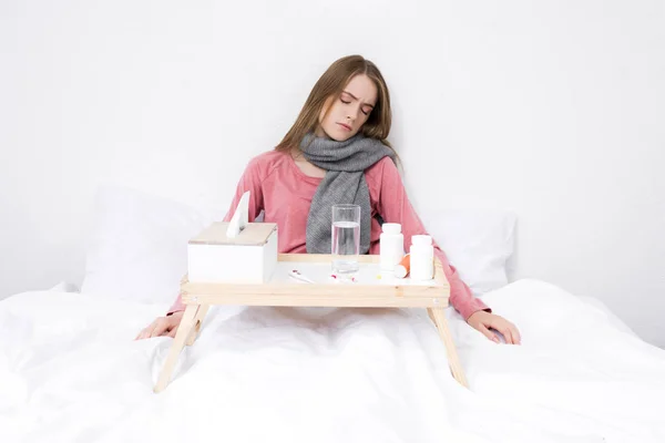 Sick woman with medicines on tray — Stock Photo, Image