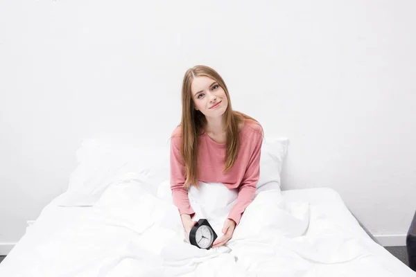 Woman with alarm clock in bed — Stock Photo, Image