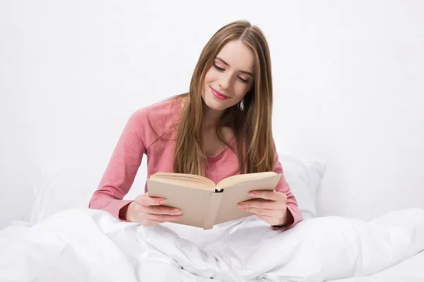 Donna che legge libro a letto — Foto Stock