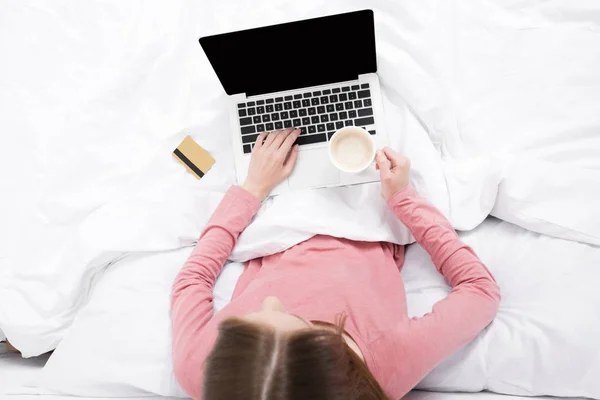 Mujer con laptop, tarjeta de crédito y café — Foto de Stock